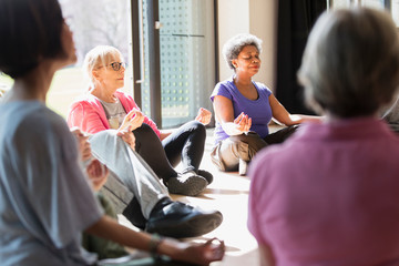 Serene active seniors meditating in circle