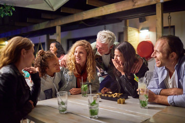 Friends hanging out, drinking on patio at night