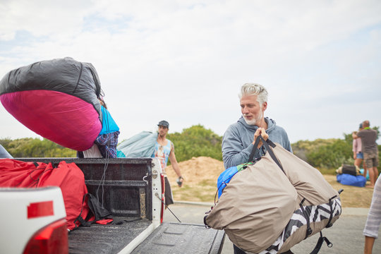 Mature male paraglider unloading parachute from truck
