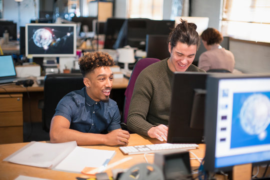 Creative businessmen working at computer in open plan office