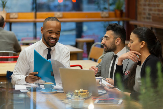 Business People Discussing Paperwork, Working In Cafe