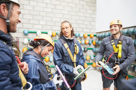 Smiling friends preparing zip line equipment
