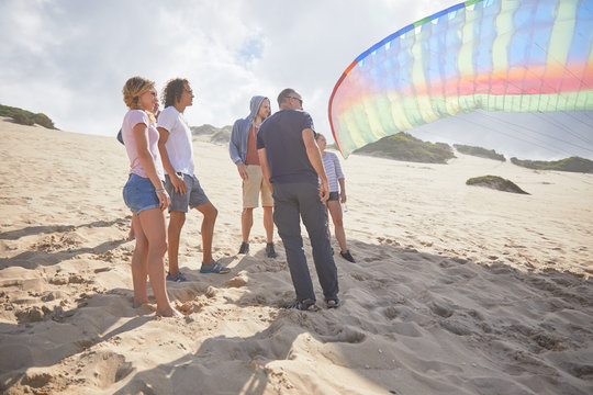 Paragliders with parachute on sunny beach