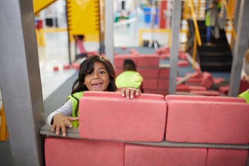 Portrait playful girl playing at construction exhibit in science center