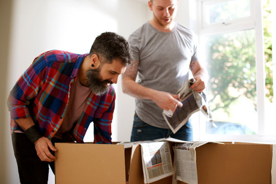 Male gay couple packing, moving out