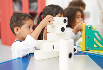 Curious boy stacking large dominos in science center