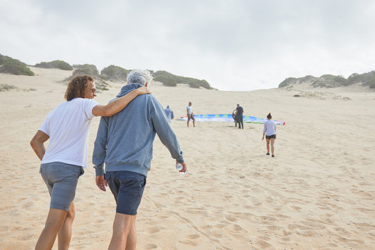 Paraglider friends walking on beach