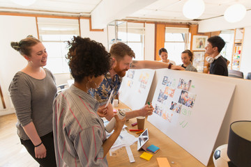 Creative designers reviewing story board proofs in office