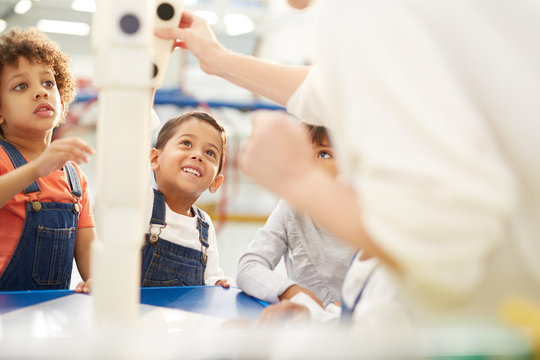 Kids playing large dominoes at interactive exhibit in science center