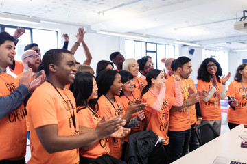 Happy hackers cheering celebrating, coding for charity at hackathon