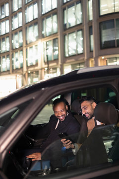 Businessman showing smart phone to driver in crowdsourced taxi