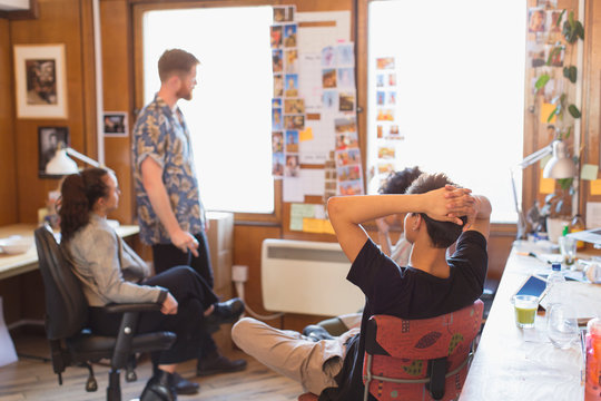 Creative designers brainstorming, reviewing photograph proofs in office