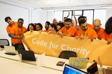 Hackers with banner coding for charity at hackathon