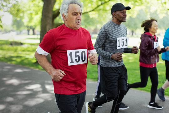 Active senior man running sports race in park
