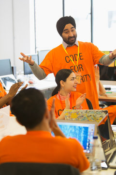 Hackers clapping, coding for charity at hackathon