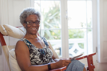 Portrait smiling, confident senior woman using digital tablet