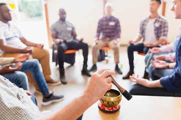 Man using singing bowl in meditation group