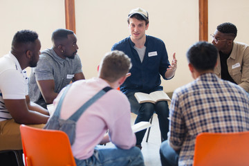 Men reading and discussing bible in prayer group