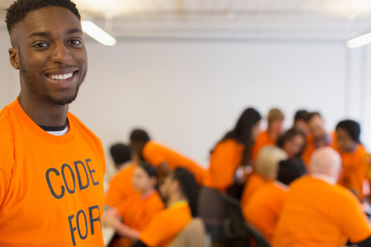 Portrait confident hacker coding for charity at hackathon