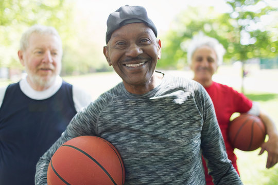 Portrait Confident, Smiling Active Senior Men Friends Basketballs In Park