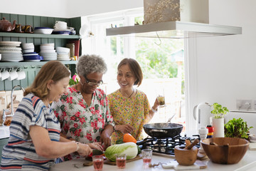 Active senior women cooking in kitchen