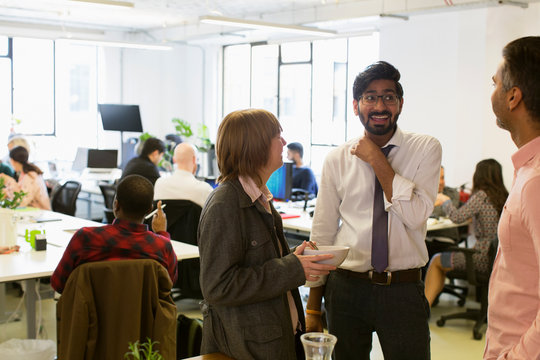 Business people talking and eating in office