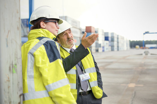 Dock manager and worker talking at shipyard