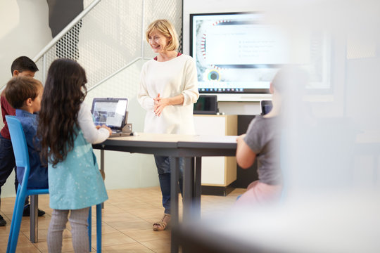 Teacher and students using laptops