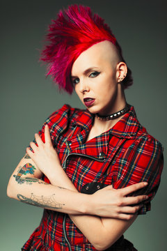 Portrait confident, cool young woman with pink mohawk and tattoos
