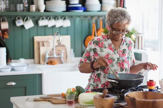 Active senior woman cooking in kitchen