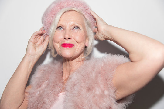 Portrait confident, glamorous senior woman wearing pink fur