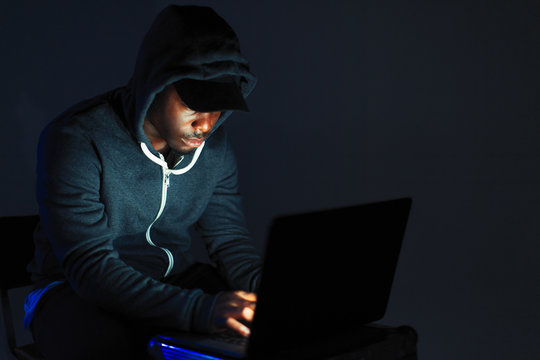 Teenage boy in hoody leaning over laptop