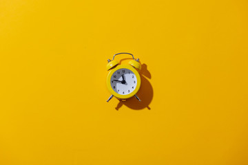 Alarm clock with two bells on yellow background