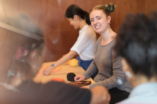 Smiling woman doing string art project