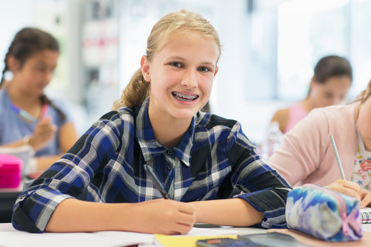 Portrait smiling, enthusiastic junior high school girl student braces in classroom