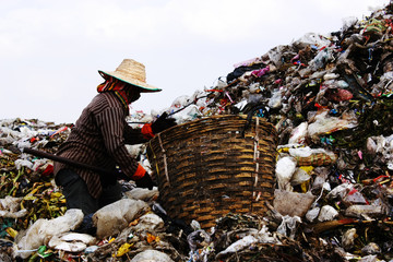 Poor people find or searching garbage for sell to reuse and recycle in landfill. This life and...