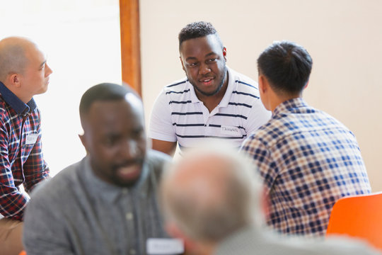 Men talking and listening in group therapy