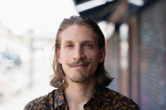 Portrait confident young male hipster with mustache