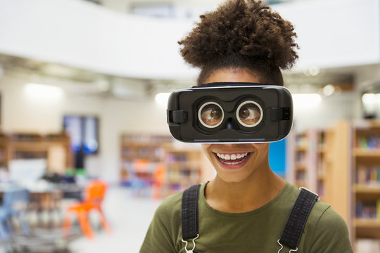 Portrait playful junior high girl student wearing virtual reality glasses