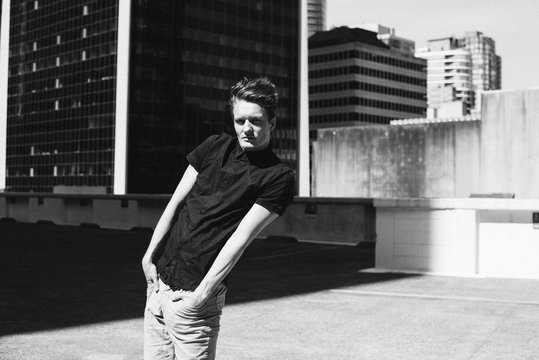 Portrait cool young man on urban rooftop