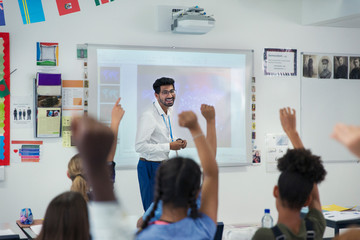 Smiling male teacher leading lesson in classroom