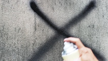 Painting peace sign with a spray can that draw new graffiti on the old wall.