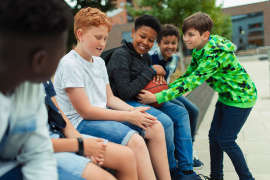 Tween boys with basketball in schoolyard