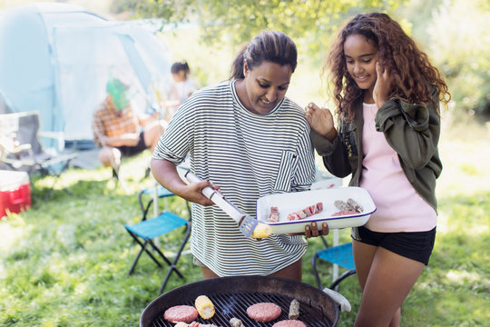 Mother and daughter barbecuing at campsite