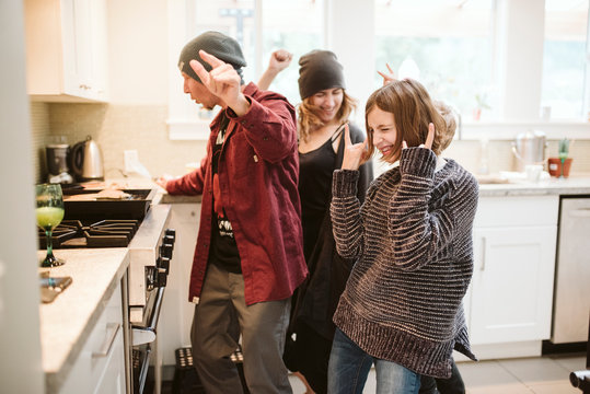 Carefree Family Dancing And Cooking In Kitchen