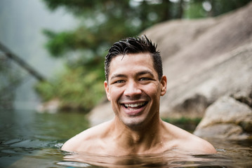 Portrait smiling, handsome young man swimming in lake