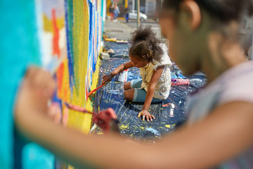 Girls painting mural on wall