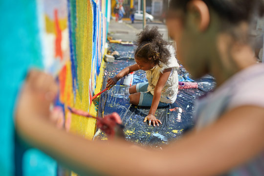 Girls painting mural on wall