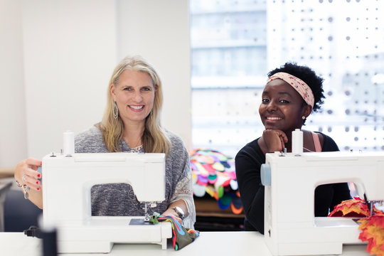 Portrait confident female fashion designers working at sewing machines