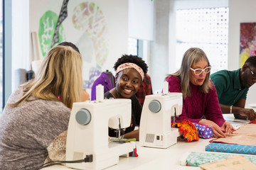 Female fashion designers working at sewing machines in studio